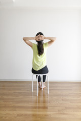 Fototapeta na wymiar 椅子を使ったストレッチ運動をする女性