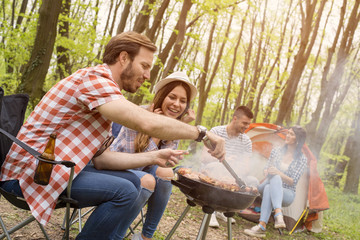 Group of friends making barbecue and having fun outdoor