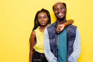 Close up portrait of a lovely young afro american couple hugging isolated on yellow background