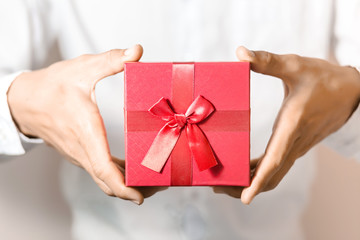 Business man hold red gift box in hands.