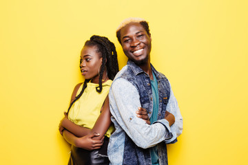 Naklejka premium Portrait of afro american couple standing back to back isolated over yellow background