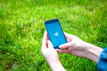 Odessa, Ukraine - APRIL 28, 2018: A mobile phone in the hand with Telegram on a green background....