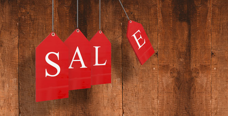 Red sale tags against weathered oak floor boards background