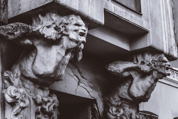bust of concrete of a terrible woman on the facade of an old house