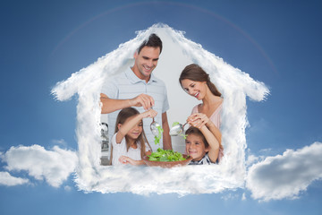 Family mixing a salad together against cloudy sky with sunshine