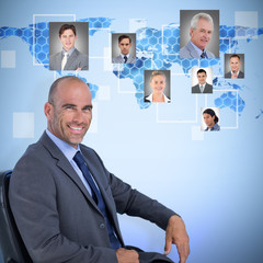 Portrait of confident businessman sitting on chair against background with hexagons and world map