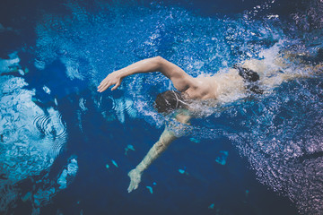 Male swimmer at the swimming pool. Underwater photo. Male swimmer.