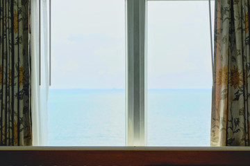 Window of the hotel with sea view in the morning time.