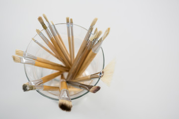 Close-up of various paintbrush in a glass jar