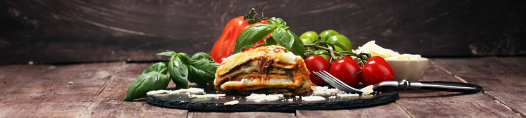 Serving of spicy traditional Italian beef lasagne in a restaurant - obrazy, fototapety, plakaty