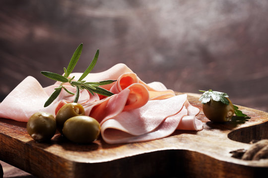 Sliced ham on wooden background. Fresh prosciutto. Pork ham sliced