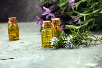 lavender oil in a glass bottle on a background of fresh flowers.