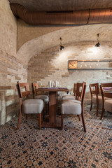 Fototapeta na wymiar Interior of vintage restaurant, tables ceiling and brick wall