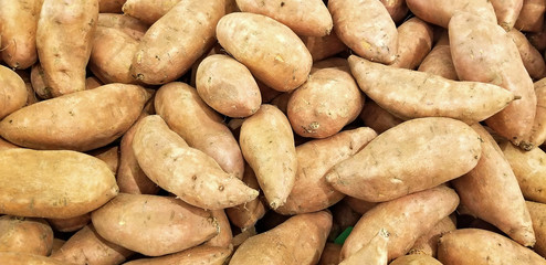pile of whole sweet potatoes at the market