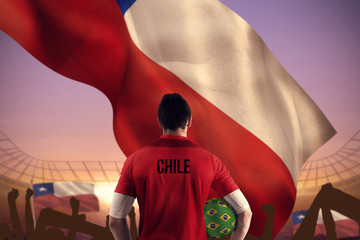Chile football player holding ball against large football stadium under purple sky