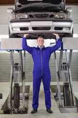 Mechanic touching the below of a car