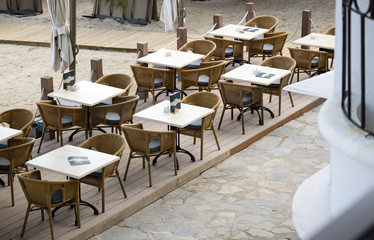 Porto Pollensa, Mallorca, Spain. 2018. Beachside tables and chairs set for breakfast in an early morning light.