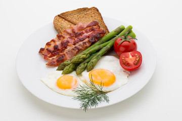 Fried eggs with bacon on the wooden table.