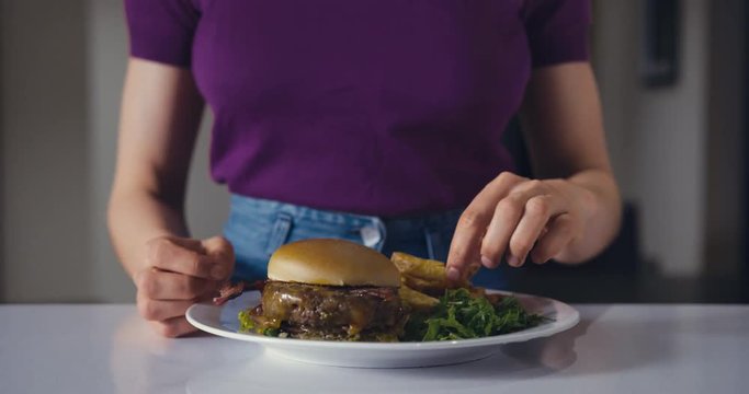 Young woman eating burger