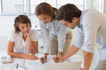 Business people working on blueprints at office