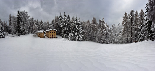 winter landscape with an isolated house on the edge of a forest