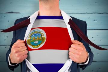 Businessman opening shirt to reveal costa rica flag against painted blue wooden planks