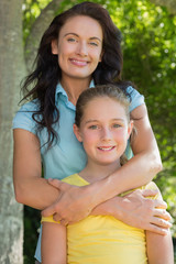 Mother and daughter standing in park