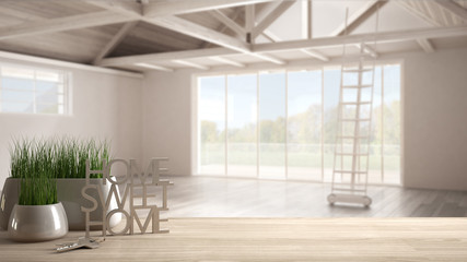 Wooden table, desk or shelf with potted grass plant, house keys and 3D letters making the words home sweet home, over open empty space, architecture interior design, copy space background