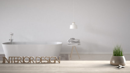 Wooden table, desk or shelf with potted grass plant, house keys and 3D letters making the words interior design, over blurred minimalist bathroom, project concept copy space background