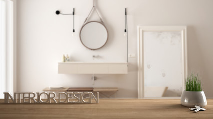 Wooden table, desk or shelf with potted grass plant, house keys and 3D letters making the words interior design, over blurred classic bathroom, project concept copy space background