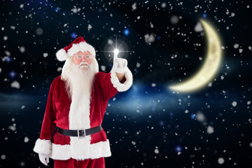 Santa Claus points at something against crescent moon in the night sky