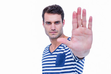 Naklejka premium Handsome hipster looking at camera and showing stop sign with hand