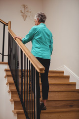 Senior woman walking up stairs