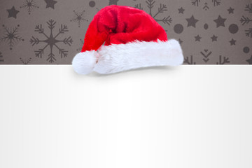 Obraz na płótnie Canvas Santa hat on poster against snowflake wallpaper pattern