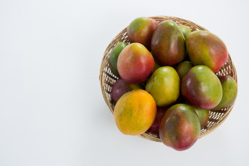 Overhead of red mangoes in wicker basket