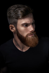 Closeup of a man with beard and mustache over black background. Perfect beard