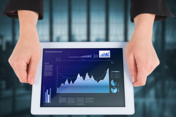 Businesswomans hands holding tablet showing business interface with graphs and data