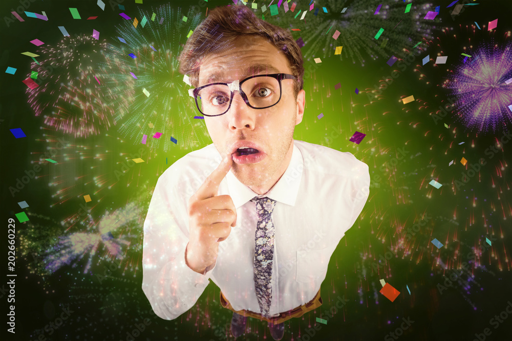 Poster young geeky businessman looking at camera against colourful fireworks exploding on black background