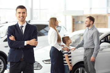 Salesman and young family in car salon