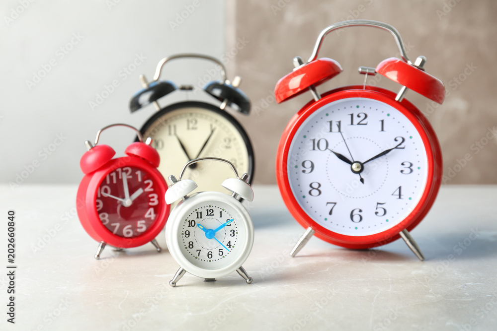 Poster many different alarm clocks on table. time change concept
