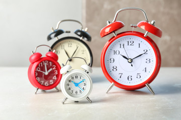Many different alarm clocks on table. Time change concept