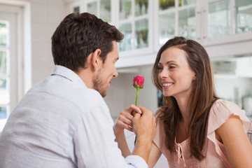 Man giving a rose to a happy woman