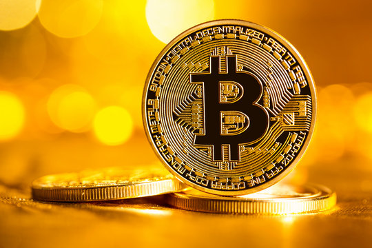 Bitcoin cryptocurrency coin on a bright gold background