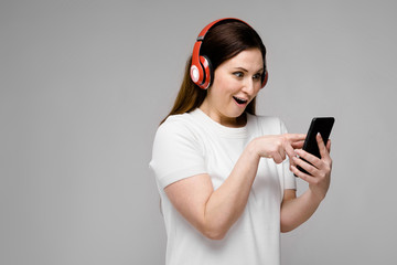 Naklejka premium Young woman with telephone and earphones
