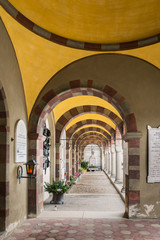 Naklejka premium Gallery of arches and colonnade inside the cemetery of San Candido, Italy.
