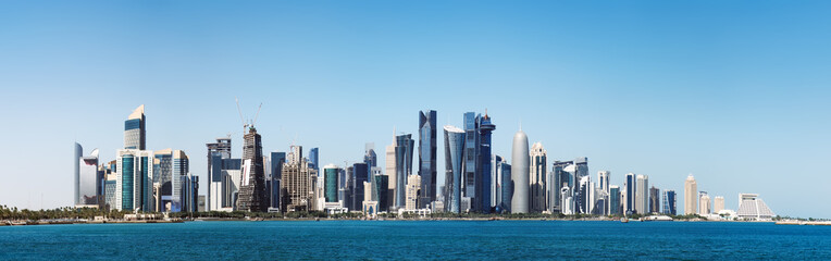 Fototapeta na wymiar The morning panoramic view of the skyscrapers of Doha from the Persian Gulf. Futuristic skyline in the financial district of Qatar