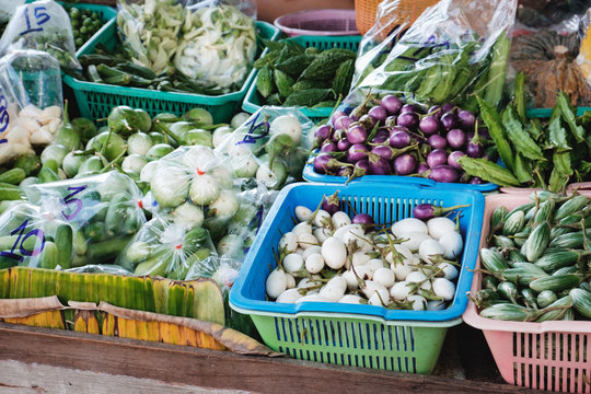 Fresh vegetable on street market in Bangkok,Thailand. Assorted eggplants of different colors with price tag in the bucket for sale.