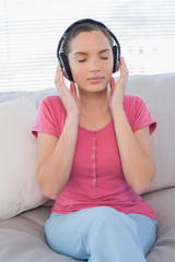 Relaxed woman listening to music on sofa