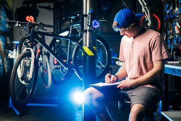 Young handsome stylish man in a cap snapback and with a tattoo small business owner selling a...