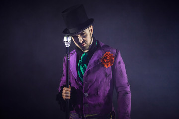 Showman. Young male entertainer, presenter or actor on stage. The guy in the purple camisole and...
